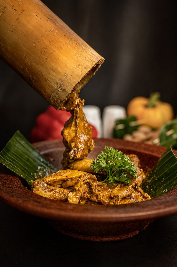 Ayam timbungan tipped from the length of bamboo it was slow-cooked in, into a clay bowl lined with banana leaf